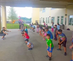 Kids exercising in a line outside a school