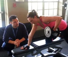 Christian Ortiz coaching a client through a dumbbell row